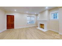 Bright living room with hardwood floors, fireplace, and large windows at 212 E Eleventh St, Salisbury, NC 28144