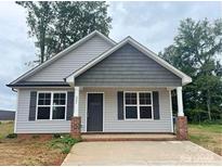 Newly built home with gray siding, gray roof, and a concrete driveway at 285 E Steele St, Salisbury, NC 28144