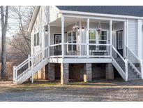 Gray house with a front porch, black railings, and white columns at 360 Country Ridge Rd, Rockwell, NC 28138