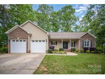 Charming single-story home with a brick-accented facade, attached two-car garage, and well-manicured lawn at 1313 Western Hills Ln, Vale, NC 28168