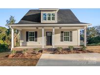 Charming home featuring a covered front porch with white columns and black shutters at 1323 Christopher Cir, Rock Hill, SC 29730