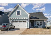 Charming light blue exterior with a two-car garage and landscaped yard at 194 Tillery Ln, Mount Gilead, NC 27306