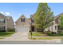 Two-story house with a white garage door and landscaping at 6107 Follow The Trl, Indian Trail, NC 28079