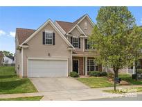 Two-story house with a white garage door and landscaping at 6107 Follow The Trl, Indian Trail, NC 28079