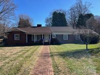 Brick ranch home with a landscaped lawn and walkway at 708 2Nd Nw Ave, Conover, NC 28613