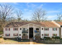 Front view of a two-story building with multiple units and ample parking at 7992 Shady Oak Trl, Charlotte, NC 28210