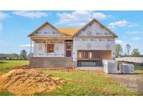 A framed two-story home featuring a covered porch and visible garage opening at 149 Tranquility Ln, Harmony, NC 28634