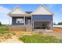 Charming blue home with a bright white trim, front porch, and a two-car garage at 149 Tranquility Ln, Harmony, NC 28634