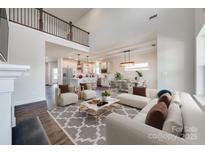 Open-concept living room with fireplace, high ceilings, and views of the kitchen and dining area offer a comfortable space at 18011 Wilbanks Dr, Charlotte, NC 28278