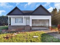 New construction home featuring a two-car garage and inviting front porch, all set in a verdant, spacious lot at 244 Little Wilkesboro Rd, Harmony, NC 28634