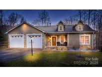 Two-story house with two-car garage, stone accents, and landscaped yard at 412 Wildlife Rd, Troutman, NC 28166