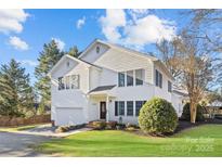 Two-story house with white siding, a large garage, and a well-maintained lawn at 5204 Sardis Rd, Charlotte, NC 28270