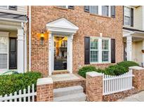 Brick front exterior with a charming white picket fence and well-manicured landscaping at 634 Atherton Way, Rock Hill, SC 29730