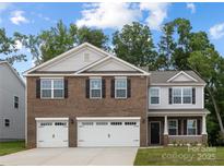 Beautiful two-story home featuring a brick and siding facade with a two car garage and manicured lawn at 8024 Kennesaw Dr, Gastonia, NC 28056