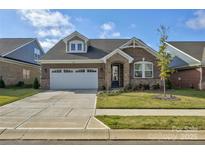 Brick ranch home with a 2-car garage and landscaped front yard at 9515 Liberty Hill Dr, Mint Hill, NC 28227