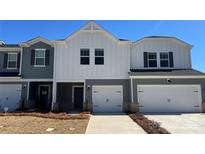 Charming townhome featuring a modern white and gray exterior with a one car garage and a well-maintained lawn at 1604 Village Grove Ln, Monroe, NC 28110