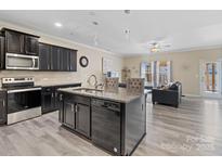 Modern kitchen features dark cabinetry, stainless steel appliances, granite countertops, and an island with bar seating at 490 Melvista Ave, Rock Hill, SC 29732