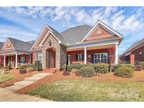 Charming brick home featuring stone accents, covered porch, and professionally landscaped front yard at 535 Chalmers Row, Rock Hill, SC 29732