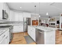 Bright kitchen with white cabinetry, granite countertops, stainless steel appliances, and hardwood flooring at 535 Chalmers Row, Rock Hill, SC 29732