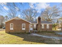 Brick ranch house with a landscaped yard and walkway at 624 Catawba N Cir, Matthews, NC 28104