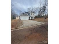 Charming two-story home with a spacious driveway and attached two-car garage on an overcast day at 104 Springdale St, Shelby, NC 28150