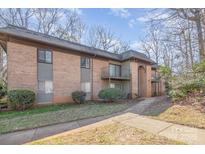 Brick exterior with a sidewalk leading to units and trees surrounding the property at 133 Orchard Trace Ln # 7, Charlotte, NC 28213