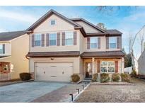 Two-story house with neutral siding, brown accents, and a paved driveway at 392 Winecoff Woods Nw Dr, Concord, NC 28027
