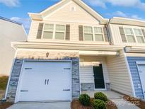 Two-story townhome with white vinyl siding, stone accents, and a two-car garage at 3922 Townes Blvd, Terrell, NC 28682