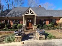 Charming brick home features a welcoming front porch, mature landscaping, and a well-manicured lawn at 990 19Th Nw Ave, Hickory, NC 28601