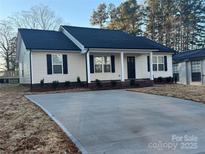 Newly constructed house with a concrete driveway and well-maintained lawn at 1014 N Main St, China Grove, NC 28023