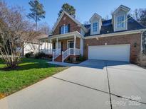 Brick two-story house with a front porch and driveway at 1385 The Xing, Rock Hill, SC 29732