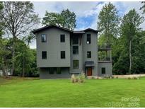 Modern two-story home boasts gray siding, a lush green lawn, and tasteful landscaping at 150 Driftwood Dr, Mooresville, NC 28117