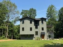 Stunning three-story home featuring modern architecture and lush landscaping at 150 Driftwood Dr, Mooresville, NC 28117