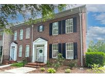 Charming brick townhome featuring a welcoming entrance, black shutters and well-maintained landscaping at 156 Singleton Rd, Mooresville, NC 28117
