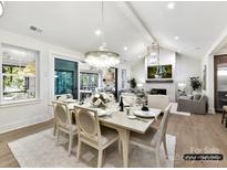 Bright open-concept dining room with modern lighting, wood floors, and access to outdoor living space at 5053 Townsend Rd, Lancaster, SC 29720