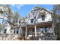 Beautiful two-story home featuring stone accents, dormer windows, and a covered front porch with large support columns at 5053 Townsend Rd, Lancaster, SC 29720