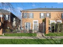 Brick townhouse with a charming front patio and wrought-iron gate at 5998 Village Nw Dr, Concord, NC 28027