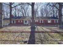 Brick ranch house with mature trees and fenced yard at 936 23Rd Ne Ave, Hickory, NC 28601