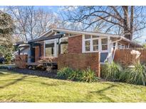 Mid-century modern home with brick and wood details, a deck, and landscaping at 3732 Mckelvey St, Charlotte, NC 28215