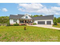Charming home featuring a well-manicured lawn, inviting front porch, and attached two-car garage at 754 Culp Ferguson Rd, Lancaster, SC 29720
