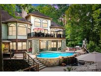 Two-story house with stone accents, a large deck, and a luxurious pool and waterfall feature at 1090 N Saunders Dr, Catawba, NC 28609