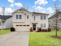 Two-story house with beige siding, a two-car garage, and a well-manicured lawn at 1414 Kings Grove Dr, York, SC 29745