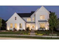 Stunning two-story white farmhouse with nighttime lighting at 2026 Thatcher Way, Fort Mill, SC 29715