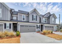 Charming townhome with gray siding, a two-car garage, well maintained lawn and a landscaped yard at 23010 Clarabelle Dr, Charlotte, NC 28273