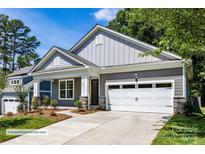 Craftsman style home with gray siding, white garage door, and landscaping at 600 Banter Ln # 27, Cramerton, NC 28032