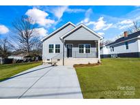 Gray house with a brick base, driveway, and landscaped lawn at 1077 Gibson St, Albemarle, NC 28001