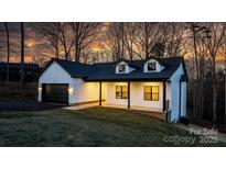 Two-story house with a white exterior, black garage door, and front porch at 115 Brentwood Dr, Maiden, NC 28650
