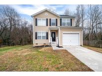 Two-story house with beige siding, attached garage, and a front yard at 1529 Brookgreen Ave, Statesville, NC 28677