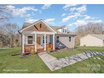 Charming craftsman style home with gray siding, a covered porch, and a landscaped yard at 828 Cabaniss Dr, Shelby, NC 28150