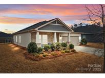 One-story home with gray siding, stone accents, and a landscaped front yard at 8932 Pennegrove Cir, Charlotte, NC 28214